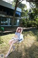 A woman sitting on a chair in the grass.